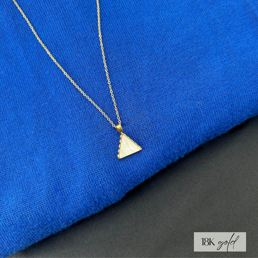 Triangle pendant necklace in 18k gold plating, on royal blue background