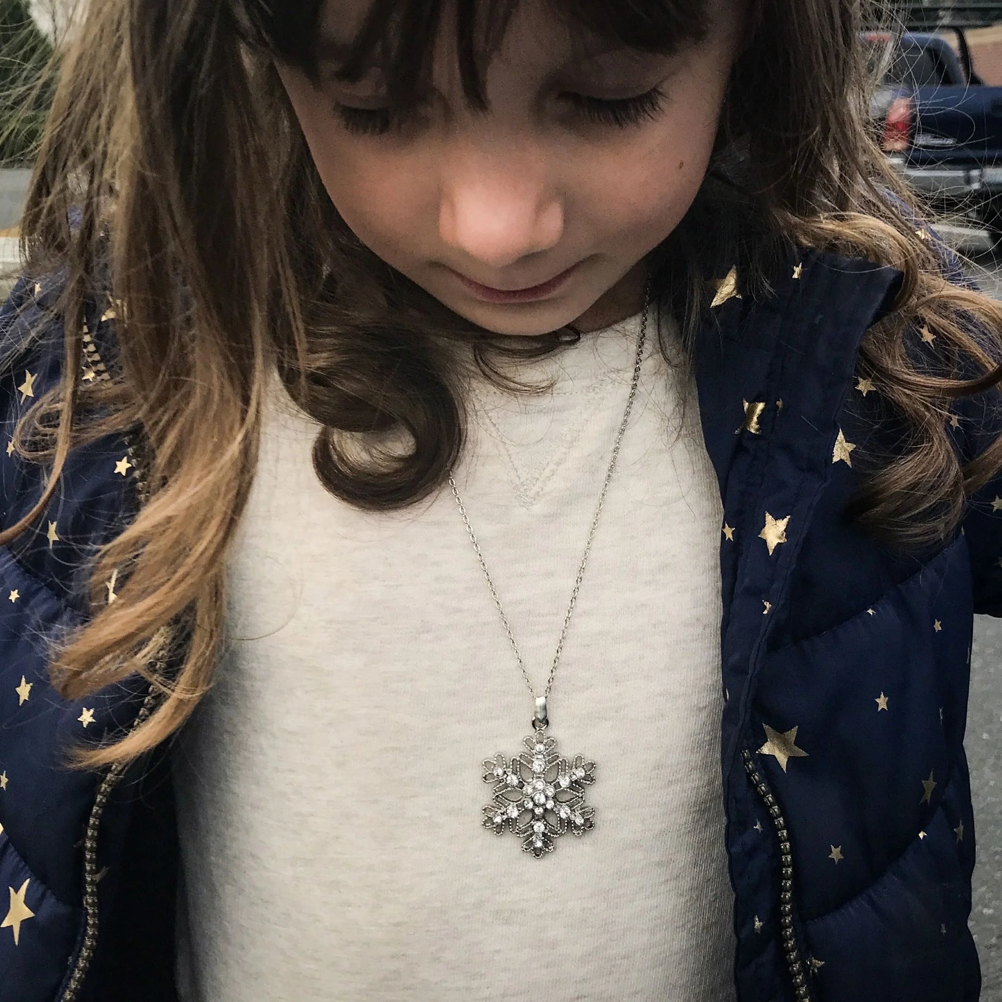 Girl who loves Queen Elsa wearing a snowflake necklace