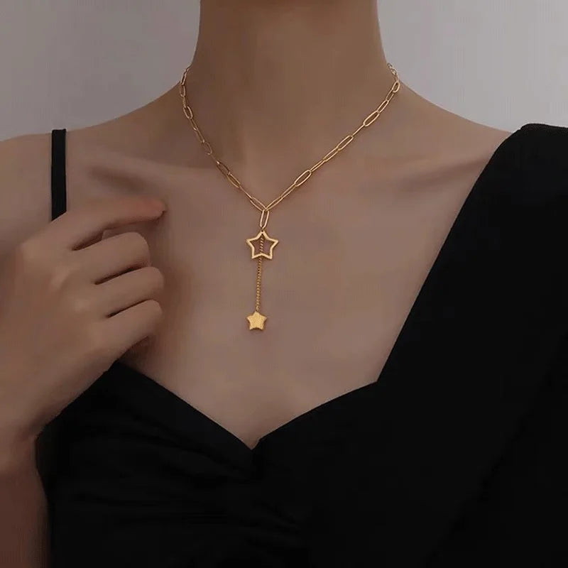Gold Y necklace with star pendants being worn